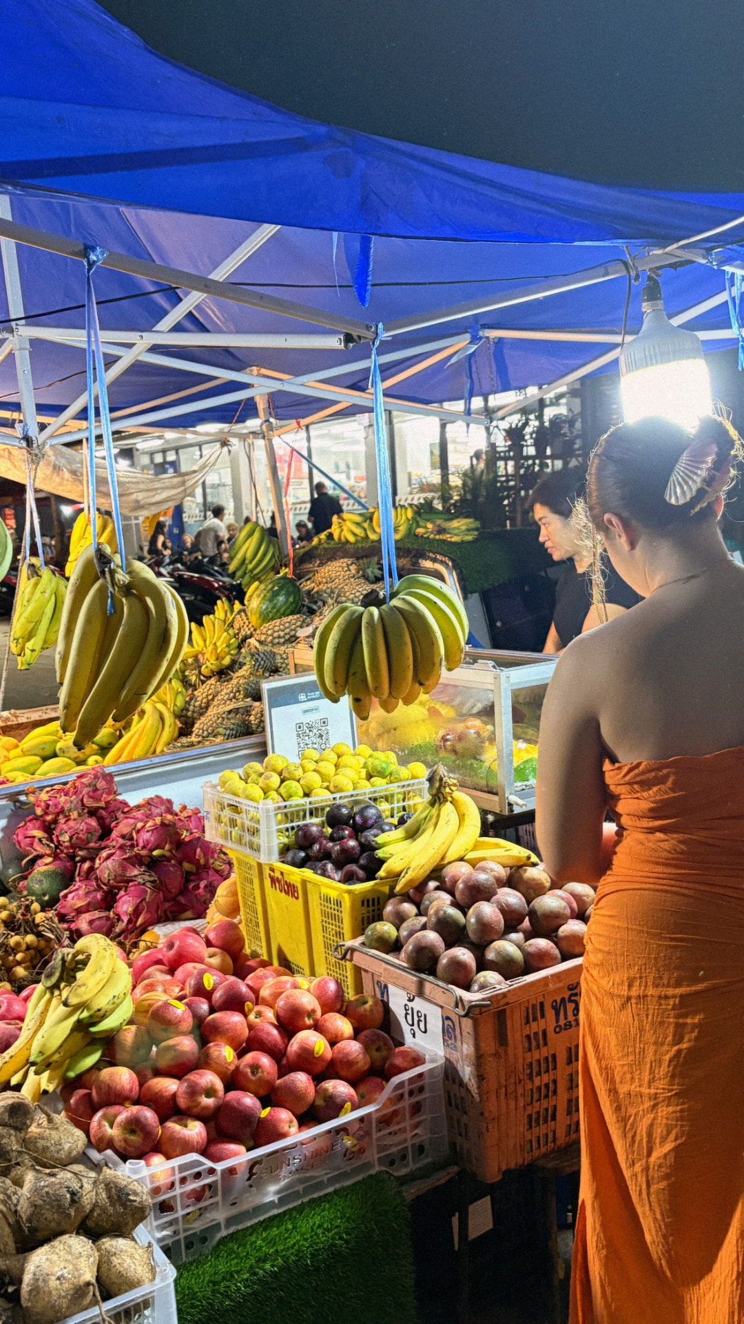 Elsa Amiri choisissant des fruits au marché